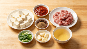Fresh ingredients for authentic Mapo Tofu: soft tofu, Pixian doubanjiang, Sichuan peppercorns, ground pork
