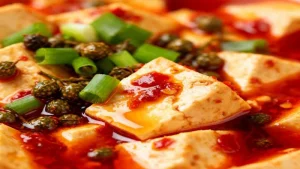 10 Mistakes That Ruin Vegan Mapo Tofu (And How to Fix Them) 63 Illustration of tofu cubes in chili sauce with scallions