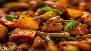 Close view of vegetable pieces and green stalks in sauce